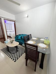 a living room with a table and chairs and a couch at Havene 11 in Dhaka