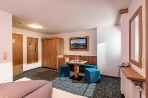 a room with a table and two blue stools at Hotel Garberwirt in Hippach