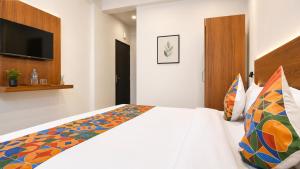 a bedroom with a bed and a flat screen tv at Hotel Evanka Brilliant Convention in Indore