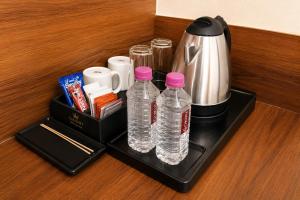 a tray with bottles of water and a coffee maker at Hotel Evanka Brilliant Convention in Indore