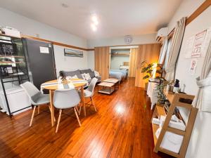 a living room with a table and chairs and a couch at HAMARs ITOMAN HOUSE - ReFaｼｬﾜｰﾍｯﾄﾞ&ﾄﾞﾗｲﾔｰ完備 - 南部観光の拠点 - 1日1組限定 in Itoman