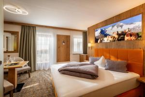 a hotel room with a large bed and a table at Hotel Garberwirt in Hippach