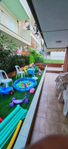a patio with a play area with tables and chairs at Argiro studios in Flogita