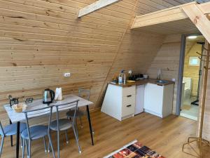 a kitchen and dining room in a log cabin with a table and chairs at UYA A-farme in Saty