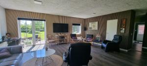 a living room filled with furniture and a flat screen tv at Kastanjegaarden in Ansager