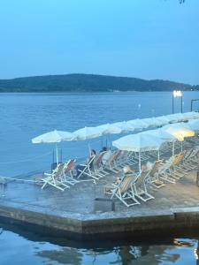 a group of chairs and umbrellas on a dock in the water at Jblago in Arona