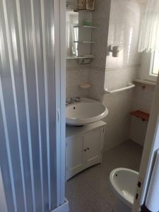 a white bathroom with a sink and a toilet at Casa vacanze nel Parco della Majella in Montenerodomo