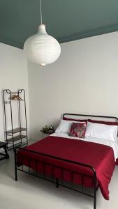 a bedroom with a bed with a red blanket and a lamp at Casa Margo in Campobasso +32 photos