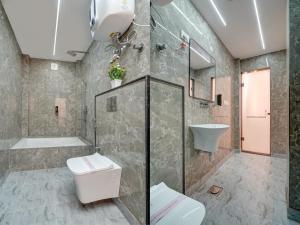 a bathroom with a toilet and a shower and a sink at Hotel Sky Nest Plazza Near Delhi IGI Airport Near Aerocity in New Delhi +35 photos