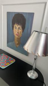 a painting of a woman on a table with a lamp at Casa Margo in Campobasso