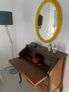 a mirror on top of a dresser with a lamp at Casa Margo in Campobasso