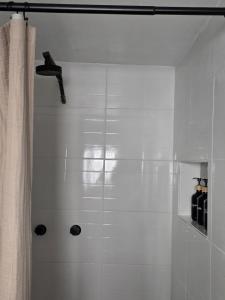 ein weißes Badezimmer mit Dusche und Duschvorhang in der Unterkunft GARÍ Loft in Chihuahua + 14 Fotos