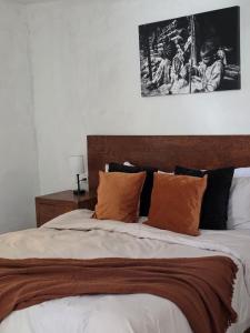 ein Schlafzimmer mit einem Bett mit orangefarbenen und schwarzen Kissen in der Unterkunft GARÍ Loft in Chihuahua