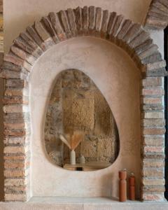 a room with a stone wall with a round window at Il Butto - Loft Etrusco in Tarquinia +14 photos