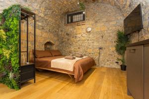 a bedroom with a bed and a stone wall at Il Butto - Loft Etrusco in Tarquinia