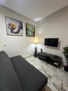 a living room with a couch and a flat screen tv at Le bungalow by mk in Nzogobeyork