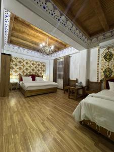a large bedroom with two beds and a chandelier at Central Asia in Bukhara