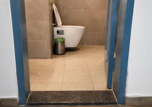 a bathroom with a toilet and a trash can at Hotel Somani Wakad in Méribel Village