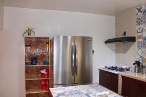 a kitchen with a stainless steel refrigerator at Luffa Hostel in Santa Lucía