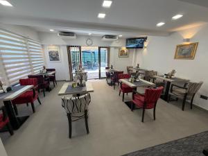 a restaurant with tables and chairs and a clock on the wall at HOTEL PERLA - Free Parking in Sarajevo