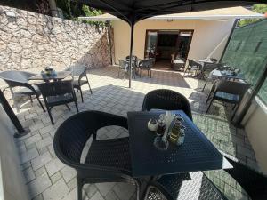 a patio with tables and chairs and an umbrella at HOTEL PERLA - Free Parking in Sarajevo
