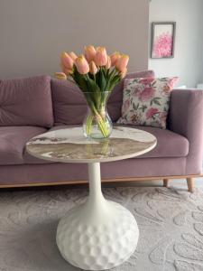 a vase of flowers on a table in a living room at APARTAMENT TETRIS - CENTRUM - Garaż in Kielce