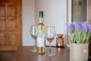 a bottle of wine and two wine glasses on a table at Ser Rooms 05 in Petra