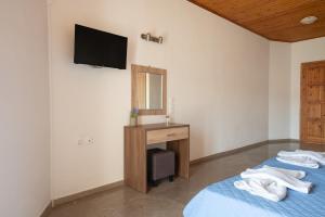 a bedroom with two beds and a desk and a mirror at Ser Rooms 05 in Petra