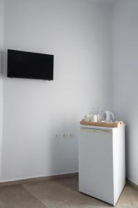 a white refrigerator with a television on a wall at Ser Rooms 05 in Petra