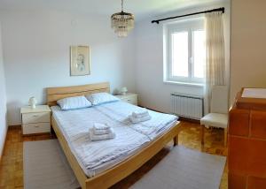 a bedroom with a bed with towels on it at Apartma Breza in Kojsko