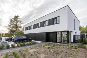 a black car parked in front of a white house at Het Meer in Rotselaar