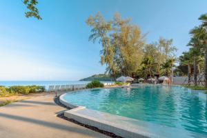 a swimming pool with the ocean in the background at Khaolak Emerald Beach Resort and Spa in Khao Lak +77 photos