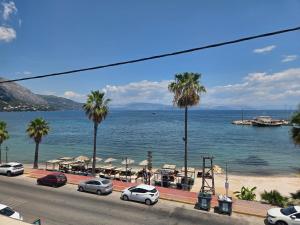 a view of a beach with palm trees and the water at Coco's Corfu Apartments in Ipsos