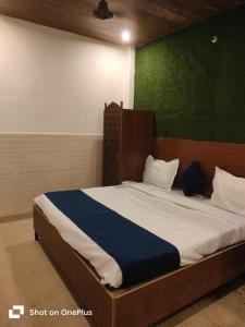 a bedroom with a large bed with a wooden headboard at vista home stay in Lucknow