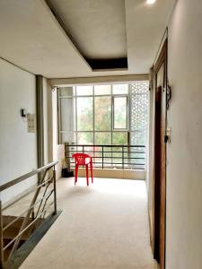 a red chair in a room with a window at vista home stay in Lucknow