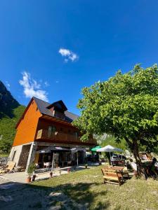 a building with benches and a tree in front of it at Old Mill Heritage Hotel in Ndërlysaj