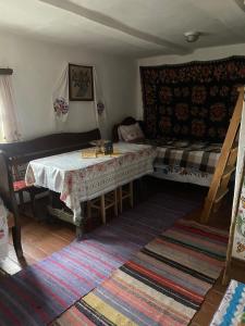 a living room with a table and a bed at Старий Хутір - Етно Хатина 1914 in Oposhnya