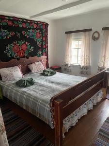 a bedroom with a large bed with a floral headboard at Старий Хутір - Етно Хатина 1914 in Oposhnya