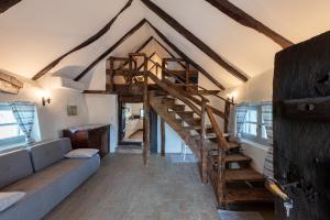 a living room with a spiral staircase in a house at Bleicher Borbirtok in Balatonkeresztúr