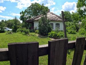 a wooden fence in front of a house at Старий Хутір - Етно Хатина 1914 in Oposhnya
