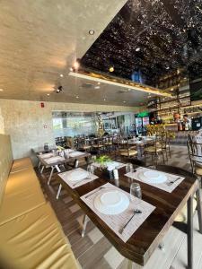 a restaurant with wooden tables and chairs in a room at Kuadro Hotel & Suites in Moalboal