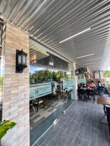 an outdoor patio with awning and tables and chairs at Kuadro Hotel & Suites in Moalboal