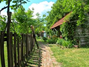 a fence next to a house with a garden at Старий Хутір - Етно Хатина 1914 in Oposhnya
