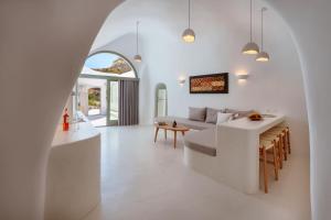 a white living room with a couch and a table at EG Cave Houses in Éxo Goniá +166 photos
