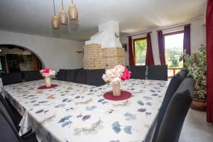 a dining room table with flowers in vases on it at Mihály Kulcsos Vendeghaz in Őriszentpéter +37 photos