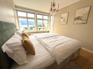 a bedroom with a white bed with a window at Charming apartment with free parking close to Ålesund center in Ålesund