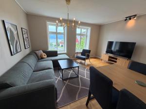 a living room with a couch and a table at Charming apartment with free parking close to Ålesund center in Ålesund