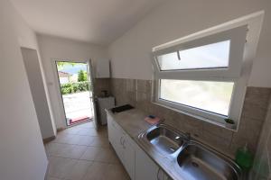 a small kitchen with a sink and a window at Apartmani Vidakovic in Igalo +35 photos