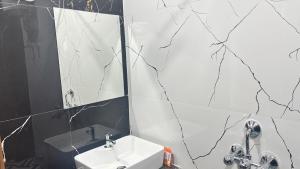 a bathroom with a sink and a mirror at Surmila International Hotel in Āsansol