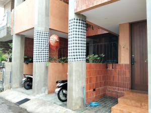a motorcycle parked outside of a building with columns at Hakon Canggu Boutique Hostel in Canggu